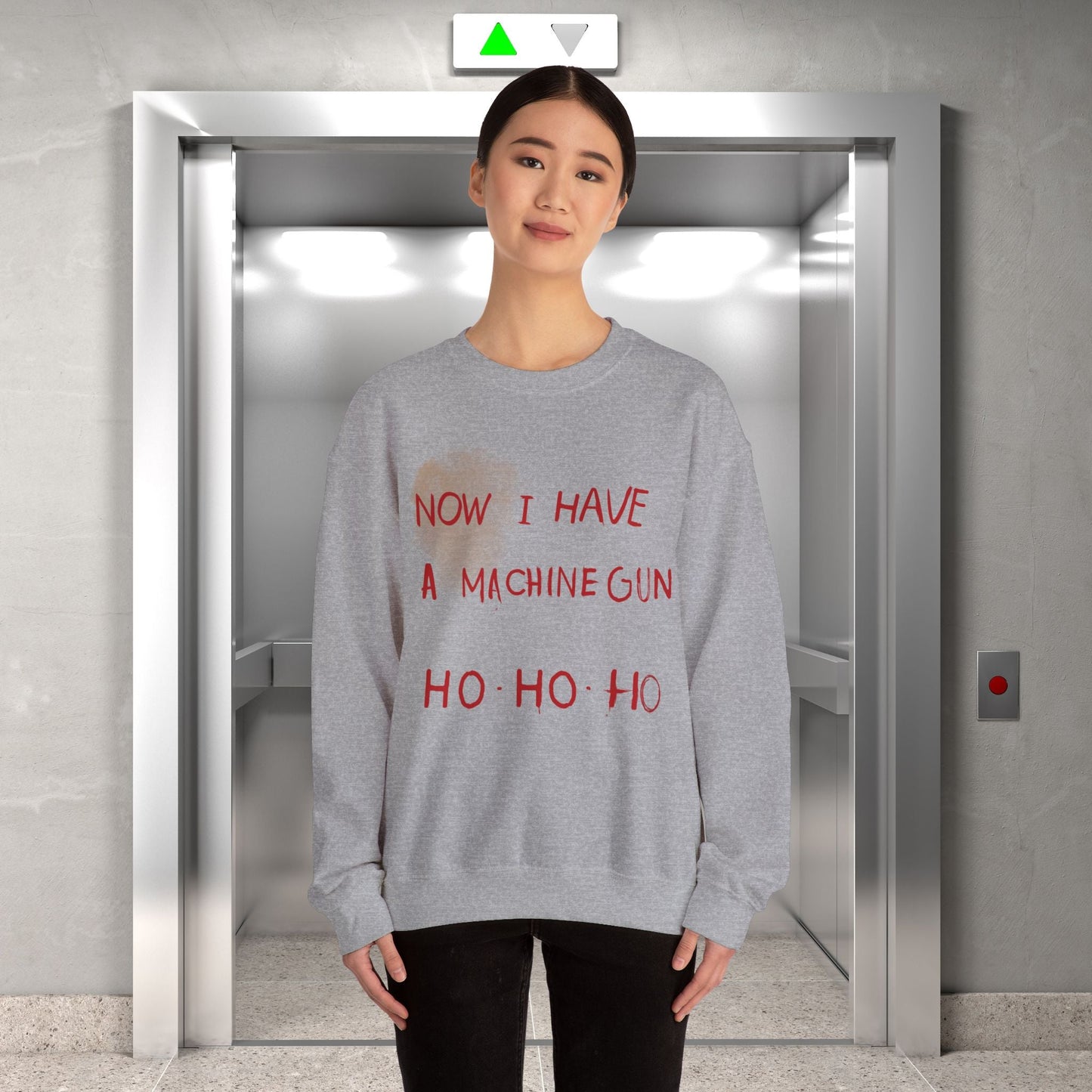 Here at t-shirts Taboo we turned that legendary scene into the most authentic Die Hard Christmas Sweater you've ever laid eyes on.  Image shows a grey christmas sweater with the words "now I have a machine gun ho ho ho"